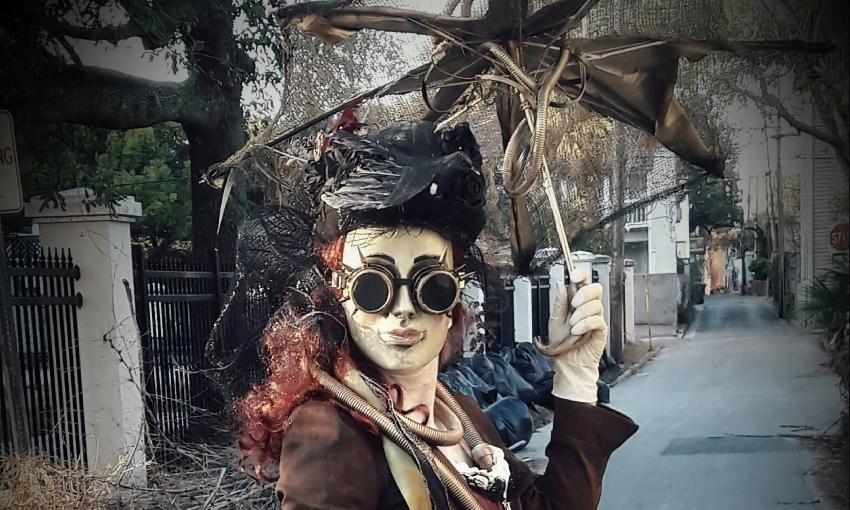 A woman with red hair, in full steampunk garb, holding a broken parasol - ghost or...?