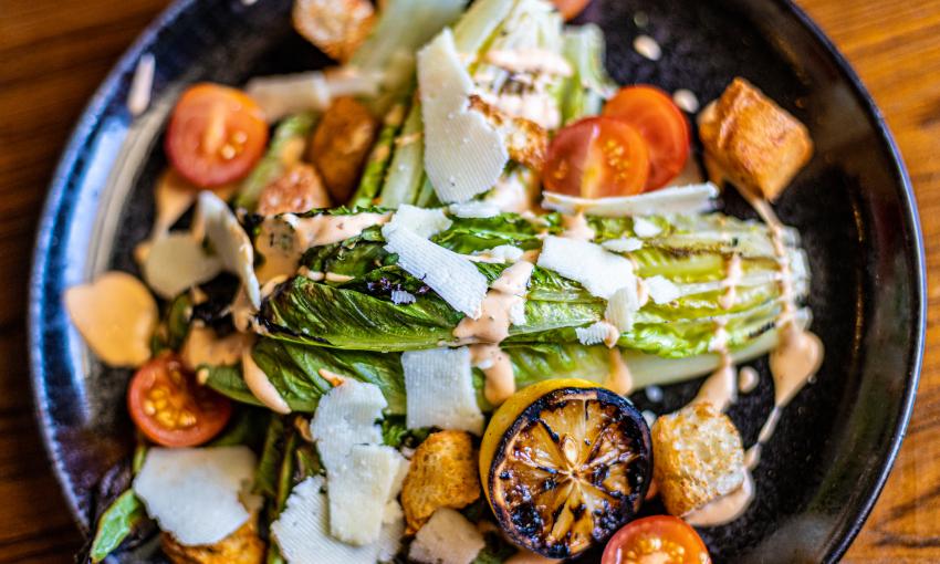 A grilled salad with shaved cheese served at Castillo Craft Bar and Kitchen