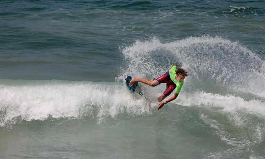 This skimboarder, in a lime green shirt, catches a wave on Vilano Beach
