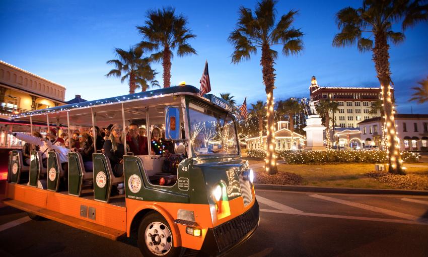 Folks aboard an Old Town Trolley Nights of Lights Tour as they pass along the bayfront with the Plaza in the background