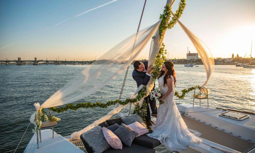 A bridal couple after their sunset wedding, held aboard a catamaran from St. Augustine Sailing