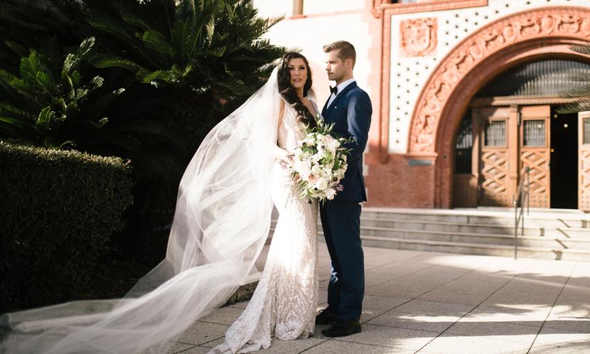 A wedded couple in the courtyard of Flagler College in St. Augustine. I Dream of Weddings Photography. 