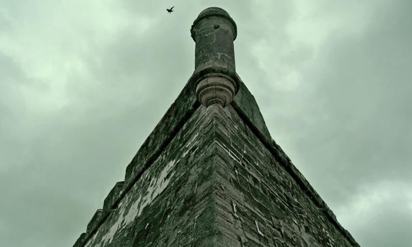 One edge of the Castillo, seen from below against a dark sky, evocative of the spirts who haunt the fort